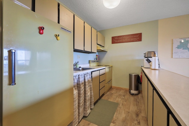 28600 N Mt Spokane Park Dr Unit 506, Mead, WA 99021 - kitchen featuring freestanding refrigerator, stove, under cabinet range hood, light countertops, and light wood-style floors