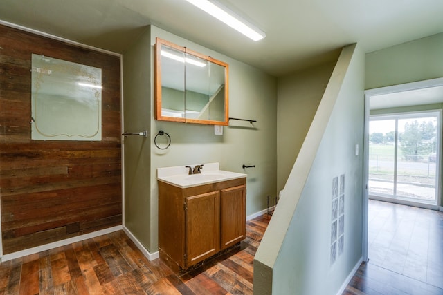 109 E 6th St, Deer Park, WA 99009 - bathroom featuring vanity, wood finished floors, and wood walls