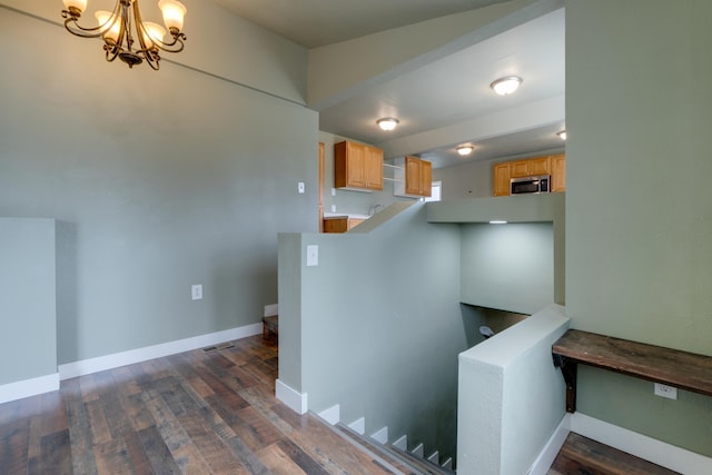 109 E 6th St, Deer Park, WA 99009 - hallway featuring dark wood finished floors, a chandelier, and an upstairs landing