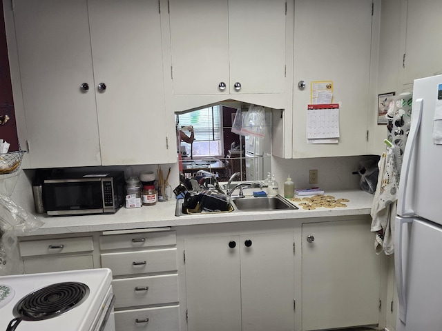 726 W 6th Ave Unit # 205, Spokane, WA 99204 - kitchen featuring freestanding refrigerator, stainless steel microwave, light countertops, and white cabinets