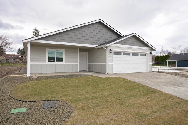 18424 E 1st Ln, Greenacres, WA 99016 - view of front of home with concrete driveway, a garage, and a front lawn