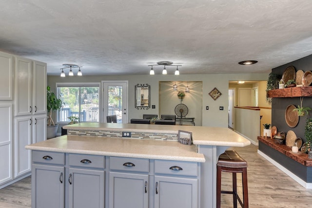 1407 S Shamrock St, Veradale, WA 99037 - kitchen featuring a breakfast bar area, light wood finished floors, light countertops, and a kitchen island