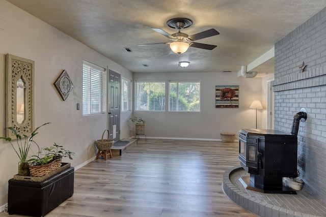 1407 S Shamrock St, Veradale, WA 99037 - sitting room with a wood stove, a ceiling fan, wood finished floors, and a textured ceiling