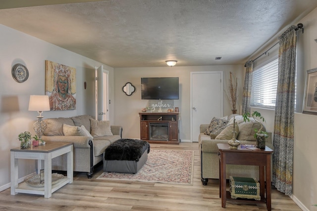 1407 S Shamrock St, Veradale, WA 99037 - living area with light wood-type flooring, a glass covered fireplace, and a textured ceiling