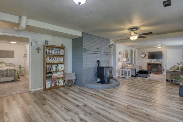 1407 S Shamrock St, Veradale, WA 99037 - living room featuring a wood stove, wood finished floors, and ceiling fan