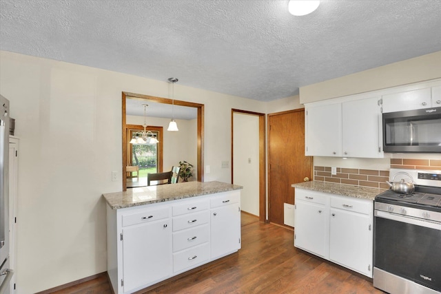 5311 W Shawnee Ave, Spokane, WA 99208 - kitchen with appliances with stainless steel finishes, backsplash, dark wood-style flooring, white cabinets, and a textured ceiling