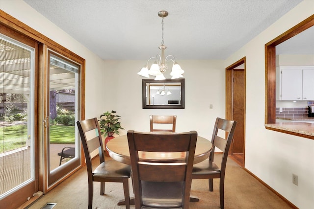 5311 W Shawnee Ave, Spokane, WA 99208 - dining space featuring light carpet, a chandelier, and a textured ceiling