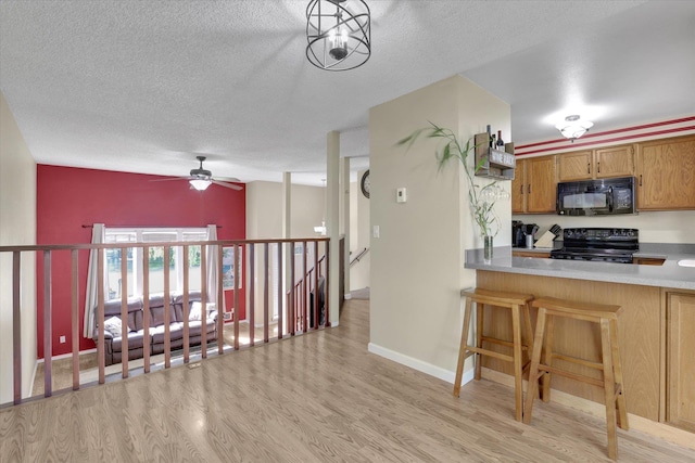 1508 N Arc St, Spokane Valley, WA 99016 - kitchen with black appliances, light wood-style floors, a textured ceiling, ceiling fan, and light countertops
