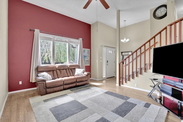 1508 N Arc St, Spokane Valley, WA 99016 - living room with stairs, ceiling fan, wood finished floors, a high ceiling, and a chandelier