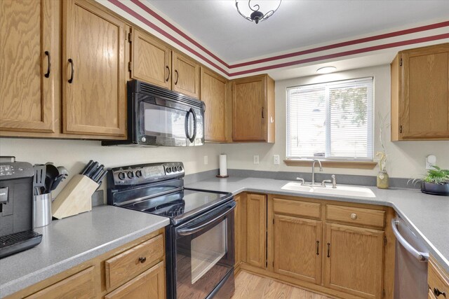 1508 N Arc St, Spokane Valley, WA 99016 - kitchen with black appliances, light countertops, light wood-type flooring, and brown cabinetry