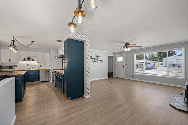 10413 E 6th Ave, Spokane Valley, WA 99206 - kitchen featuring blue cabinetry, appliances with stainless steel finishes, wood counters, ceiling fan, and tasteful backsplash