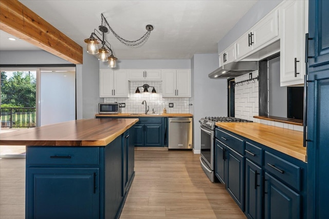 10413 E 6th Ave, Spokane Valley, WA 99206 - kitchen with butcher block countertops, appliances with stainless steel finishes, blue cabinetry, white cabinets, and beam ceiling