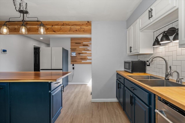 10413 E 6th Ave, Spokane Valley, WA 99206 - kitchen with butcher block counters, blue cabinets, dishwasher, black microwave, and tasteful backsplash