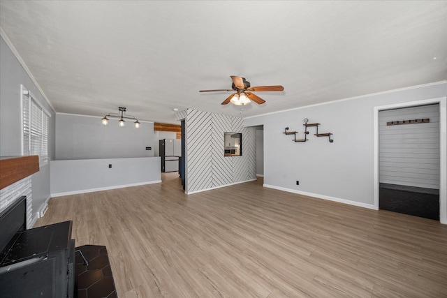 10413 E 6th Ave, Spokane Valley, WA 99206 - unfurnished living room featuring ceiling fan, crown molding, light wood-type flooring, and a glass covered fireplace