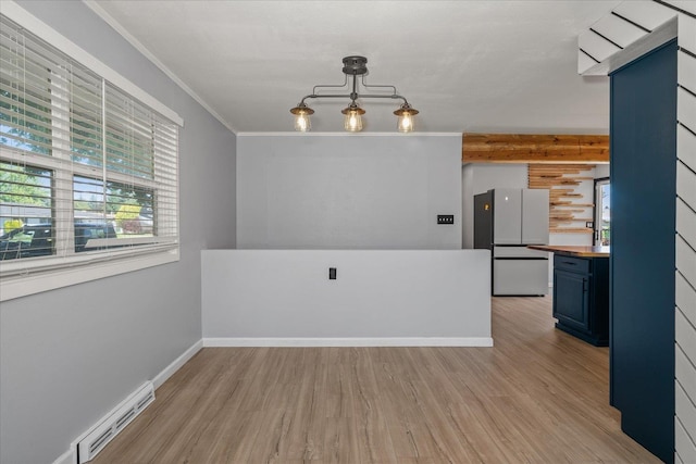 10413 E 6th Ave, Spokane Valley, WA 99206 - unfurnished dining area with a baseboard radiator, light wood finished floors, and crown molding