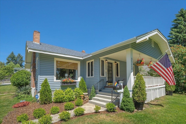 3328 W Kiernan Ave, Spokane, WA 99205 - view of front facade with a porch, a chimney, a front yard, and roof with shingles