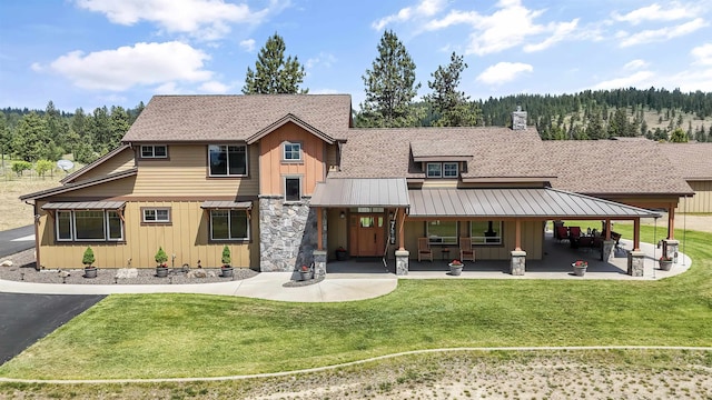 21617 E Harvard Vistas Ln, Newman Lake, WA 99025 - view of front facade featuring board and batten siding, a front yard, a metal roof, and a standing seam roof