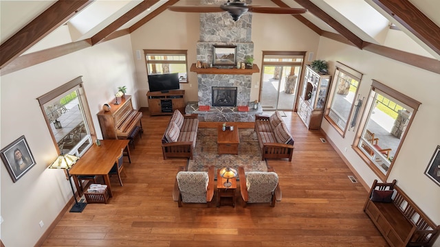 21617 E Harvard Vistas Ln, Newman Lake, WA 99025 - living room with high vaulted ceiling, beam ceiling, a fireplace, ceiling fan, and wood finished floors
