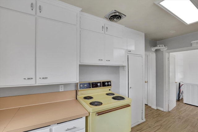 314 E Everett Ave, Spokane, WA 99207 - kitchen with white range with electric stovetop, light wood-style floors, white cabinets, and light countertops