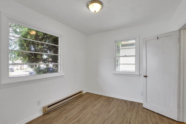 314 E Everett Ave, Spokane, WA 99207 - unfurnished bedroom featuring baseboard heating and light wood finished floors