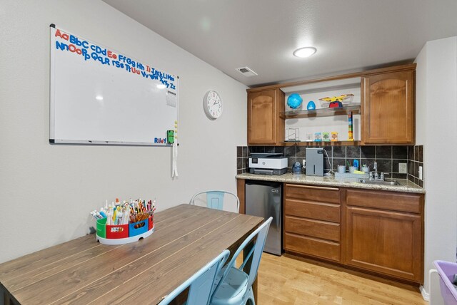 9805 N Jesse Ct, Spokane, WA 99208 - kitchen featuring fridge, light wood-style floors, backsplash, brown cabinets, and open shelves