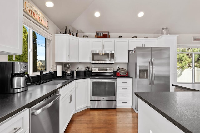 9805 N Jesse Ct, Spokane, WA 99208 - kitchen with appliances with stainless steel finishes, white cabinets, dark countertops, recessed lighting, and lofted ceiling