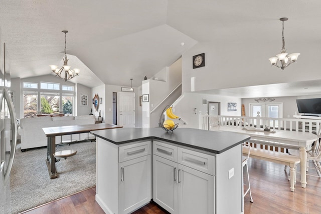 9805 N Jesse Ct, Spokane, WA 99208 - kitchen featuring a chandelier, vaulted ceiling, dark countertops, a center island, and open floor plan