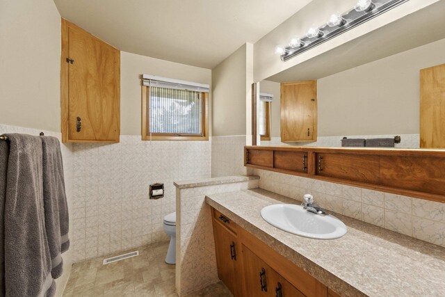 2620 S Pines Rd, Spokane Valley, WA 99206 - bathroom featuring vanity, wainscoting, and tile walls