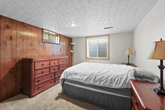 2620 S Pines Rd, Spokane Valley, WA 99206 - bedroom with light colored carpet, a textured ceiling, and wooden walls