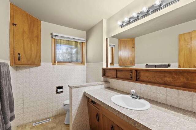 2620 S Pines Rd, Spokane Valley, WA 99206 - bathroom featuring vanity, tile walls, and wainscoting