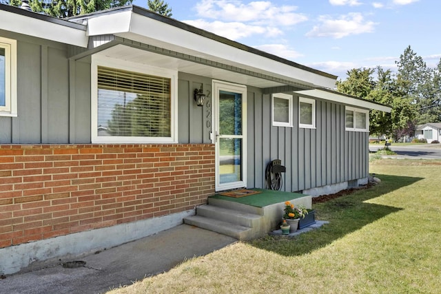 2620 S Pines Rd, Spokane Valley, WA 99206 - property entrance with board and batten siding, a yard, and brick siding