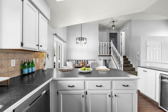 8805 N Greenwood St, Spokane, WA 99208 - kitchen with a peninsula, wine cooler, white cabinets, a chandelier, and tasteful backsplash