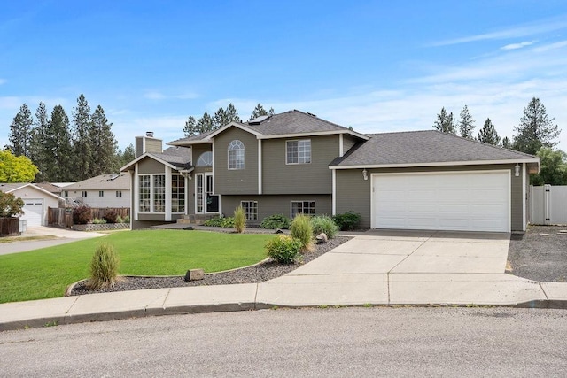 8805 N Greenwood St, Spokane, WA 99208 - split level home with concrete driveway, an attached garage, a chimney, and a shingled roof
