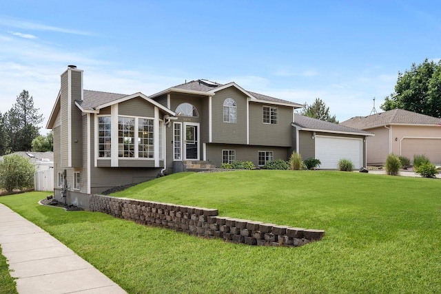 8805 N Greenwood St, Spokane, WA 99208 - split level home featuring a garage, a chimney, and a front lawn