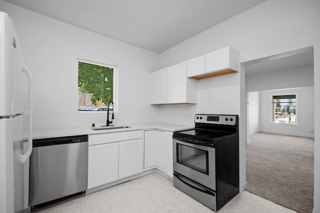 1604 W Maxwell Ave, Spokane, WA 99201 - kitchen featuring stainless steel appliances, white cabinets, light countertops, and light carpet