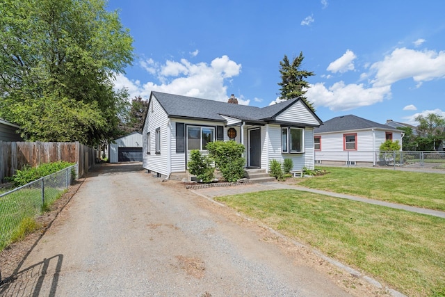 10021 N Whittier St, Spokane, WA 99218 - view of front of house featuring a chimney, a garage, an outbuilding, and a shingled roof