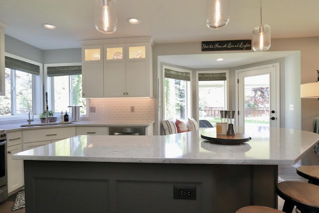 5522 E Cargill Ln, Colbert, WA 99005 - kitchen featuring white cabinets, a kitchen island, a breakfast bar, pendant lighting, and light stone countertops