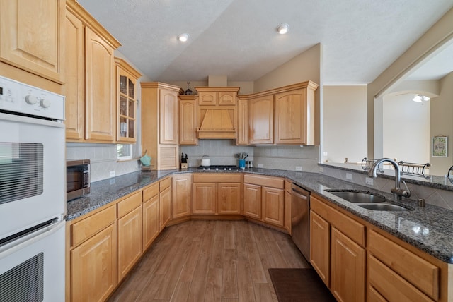 5506 S Southview Ln, Spokane, WA 99223 - kitchen featuring appliances with stainless steel finishes, light wood-style floors, dark stone counters, glass insert cabinets, and decorative backsplash