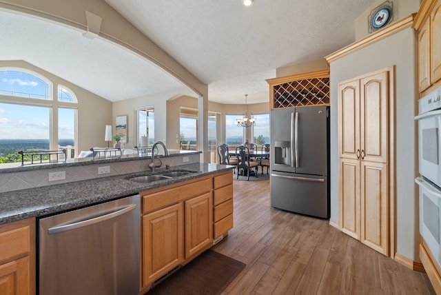 5506 S Southview Ln, Spokane, WA 99223 - kitchen featuring appliances with stainless steel finishes, lofted ceiling, light wood-type flooring, plenty of natural light, and a chandelier