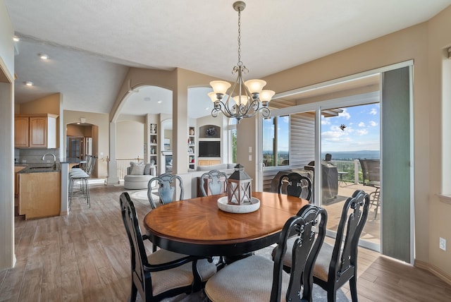 5506 S Southview Ln, Spokane, WA 99223 - dining room featuring a chandelier, arched walkways, and light wood finished floors