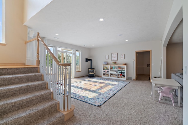 5506 S Southview Ln, Spokane, WA 99223 - staircase featuring a wood stove, carpet, arched walkways, and recessed lighting