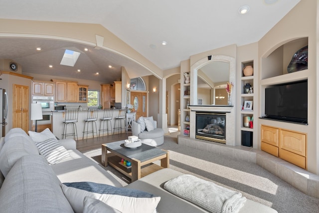 5506 S Southview Ln, Spokane, WA 99223 - living area with arched walkways, built in shelves, a fireplace, recessed lighting, and vaulted ceiling