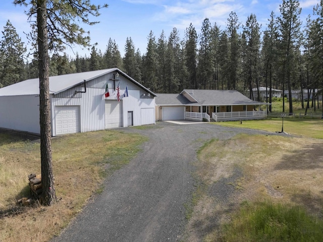7905 W Seven Mile Rd, Nine Mile Falls, WA 99026 - view of front of house featuring a porch, driveway, a garage, a front yard, and an outbuilding