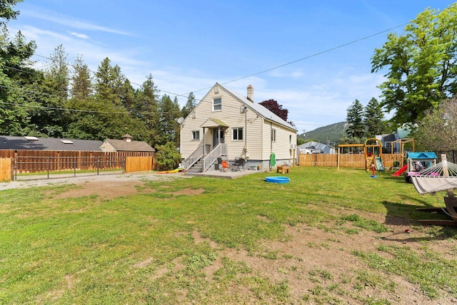 561 E Forest Ave, Colville, WA 99114 - rear view of property with a chimney, a playground, a fenced backyard, and entry steps