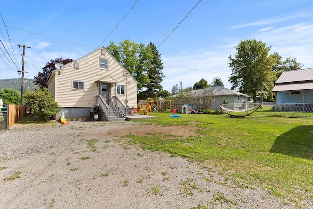 561 E Forest Ave, Colville, WA 99114 - rear view of property with entry steps, a playground, and a fenced backyard