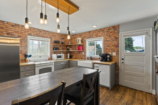 561 E Forest Ave, Colville, WA 99114 - kitchen with white appliances, gray cabinets, plenty of natural light, brick wall, and pendant lighting