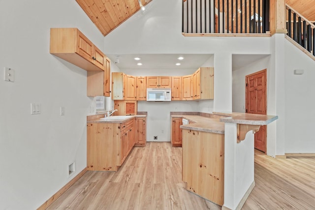 5011B Mason Rd, Clayton, WA 99110 - kitchen with white microwave, light brown cabinets, light wood finished floors, a kitchen breakfast bar, and recessed lighting
