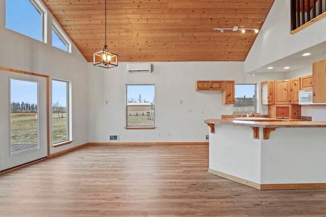5011B Mason Rd, Clayton, WA 99110 - kitchen with high vaulted ceiling, wood ceiling, white microwave, a wall mounted air conditioner, and hanging light fixtures