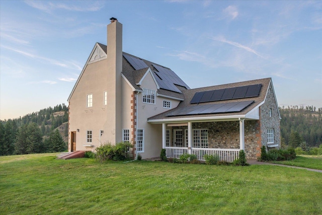 4408 E Spangle Creek Rd, Valleyford, WA 99036 - view of home's exterior with a yard, roof mounted solar panels, stucco siding, and a chimney