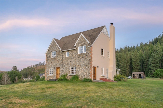 4408 E Spangle Creek Rd, Valleyford, WA 99036 - view of property exterior featuring stone siding, a lawn, a chimney, and a forest view
